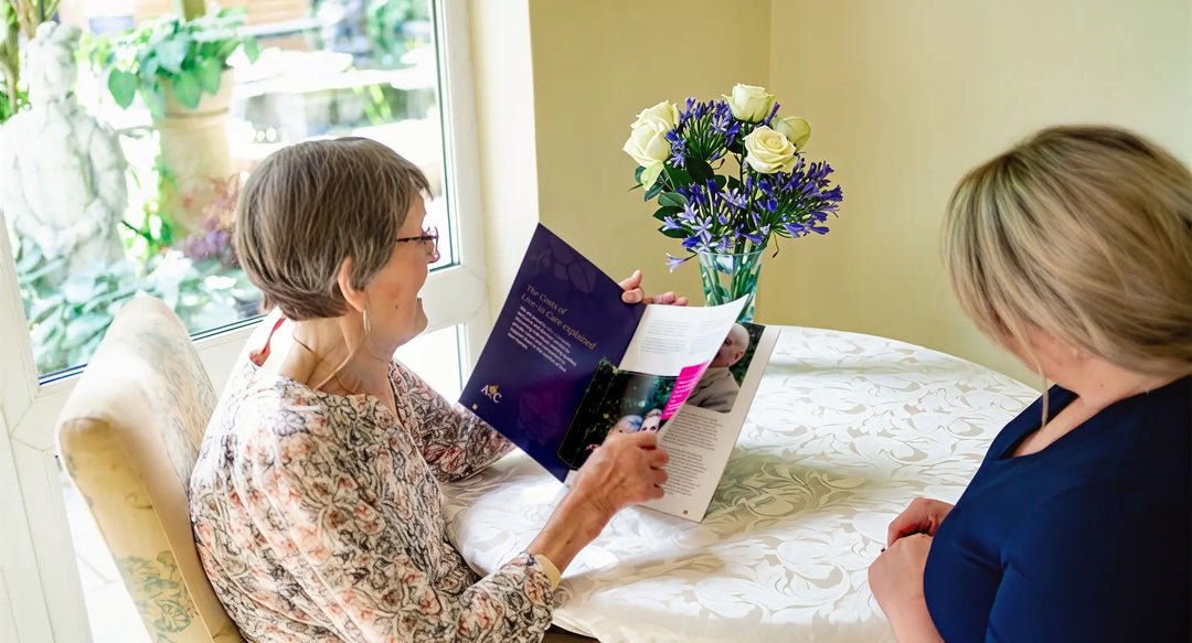 Elderly lady considering live-in care costs reading a brochure