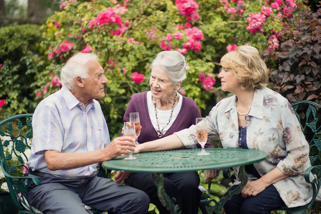 Elderly couple at home in garden with live-in carer providing support in a comfortable setting