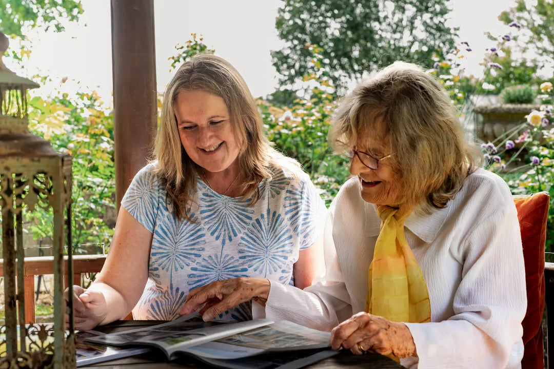 Live-in carer supporting an elderly client outdoors in a garden setting in the UK