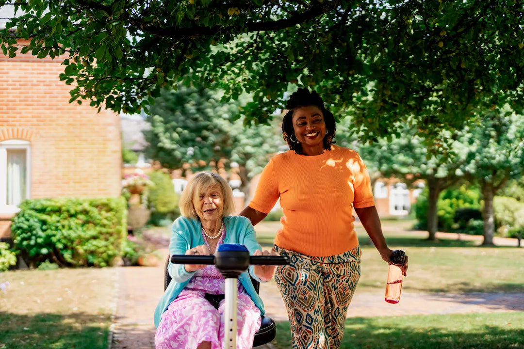 A live-in carers walking with her client who is on a mobility scooter